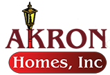 Akron Homes Logo. Akron homes text in red with gold lamppost in the K.